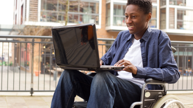 Young man in wheelchair using computer