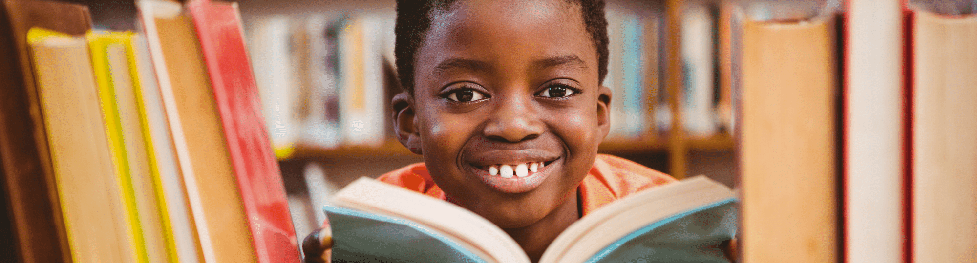 Second grade boy reading in library