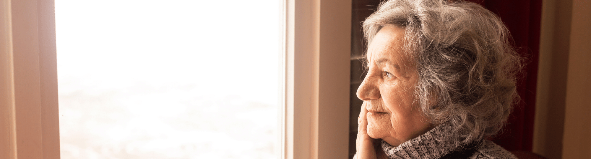 Elderly woman looking out window