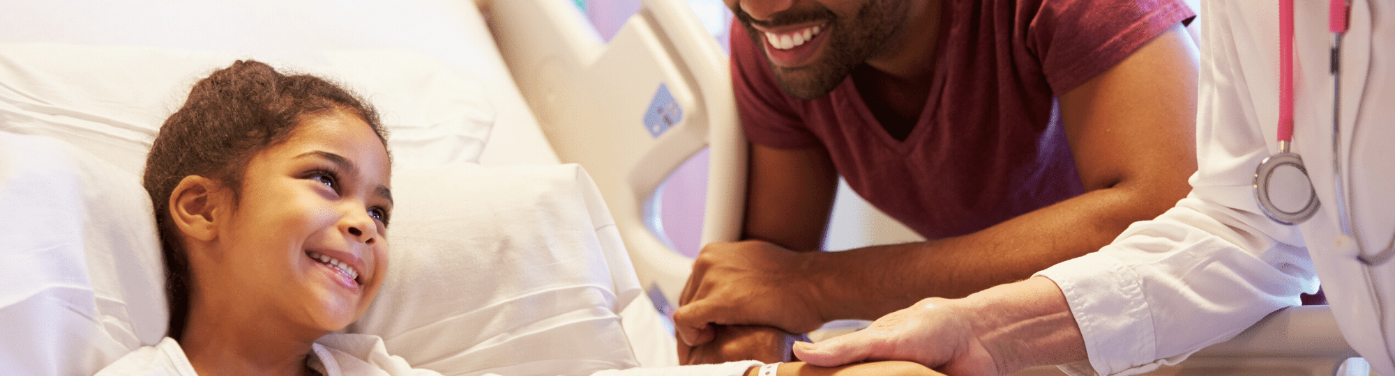 child in hospital bed smiling