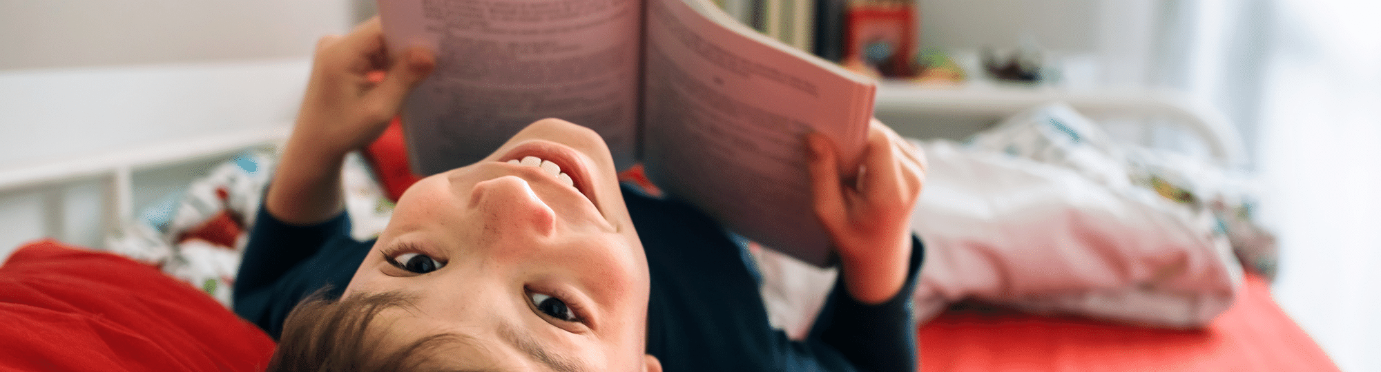 Child reading a book and smiling