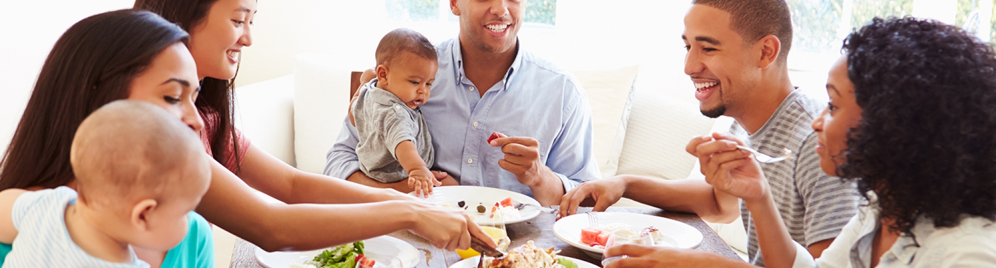 five adults and two babies sharing a meal