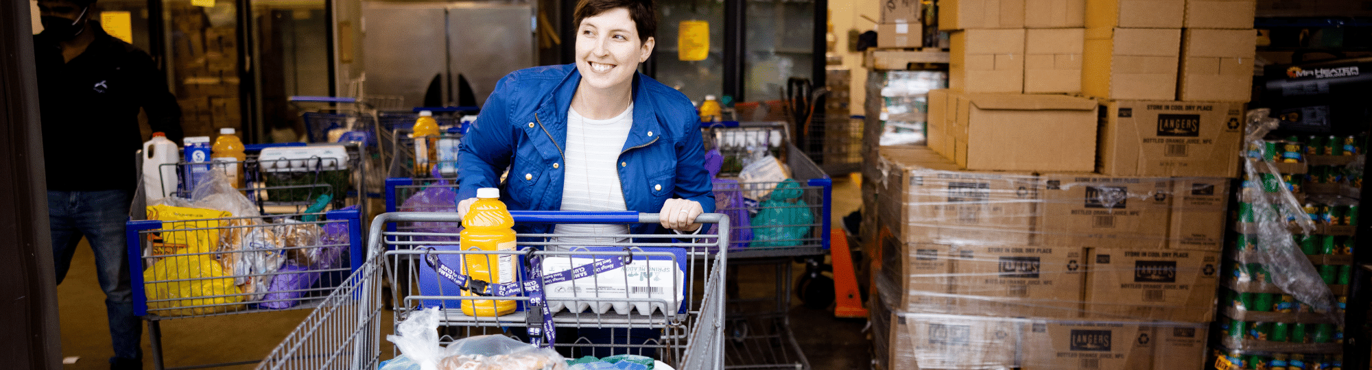 Woman pushing full shopping cart