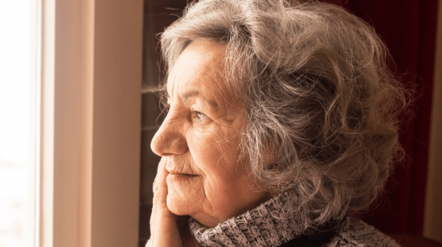 Elderly woman looking out window