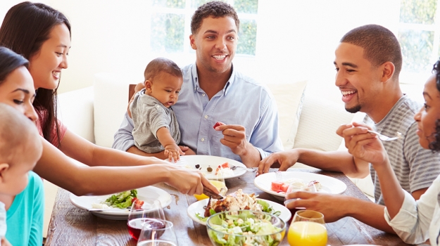 five adults and two babies sharing a meal