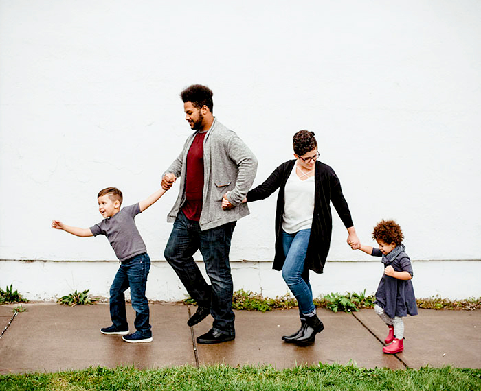 family of four walking on the sidewalk